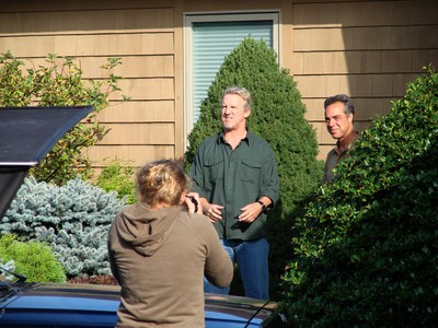 The two actors exit Neuman's house.