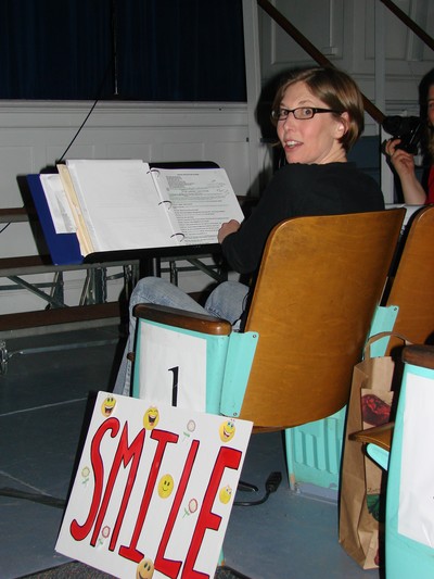 Director Hilary Vallet with her cue card, SMILE.