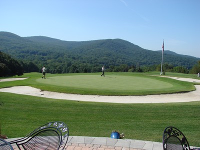 Food and drink may be enjoyed on the clubhouse patio, with a panoramic view of the mountains and the first hole.