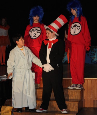The Cat in the Hat tells Jojo a story, while Thing 1 and Thing 2 listen in.