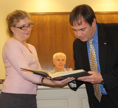 Trustee Mark Edsall signs the oath of office.