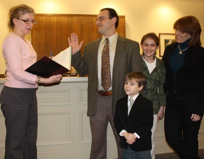 Andrew Argenio is sworn in as trustee as his family watches.