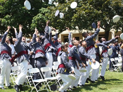 The new graduates celebrate by throwing their caps in the air.