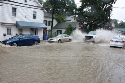 Flood waters race down Main Street in Cornwall shortly before noon on Sunday.