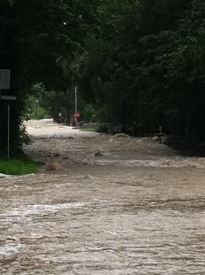 The surging waters of Canterbury Creek flooded down Continental Road near the end of Boulevard.  Photo by Katie Maguire.