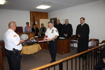 Judges preside over the retiring of the flag that hung in Judge Thomson's courtroom.