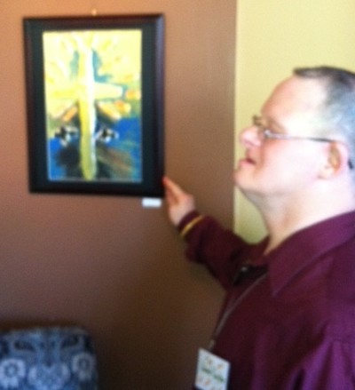 Real Art Show at 2 Alices. Photo by Jim Lennon. AHRC Artist Edward Gayton points out his artwork.