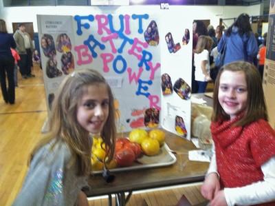 Carley Dunkel and Rachel Rosenberger demonstrate how an electrical current can be generated using citrus.
