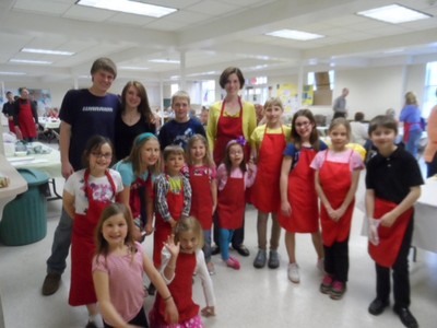 L->R) Young Children who waited tables in forefront: Brigid Grodence, Calli Balcombe, Sofia Taylor, Annika Taylor, Brady Balcombe, Alice Phillips, Emma Callahan, Molly Cameron, Ashlynn Mullen, Maggie Cameron, Charley Winchell, with teens Max Cameron, Sarah Hambrick and, Zack Carey standing left of Pastor Patricia Callahan in the background, at the Roast Beef Diner on Saturday, April 27. 