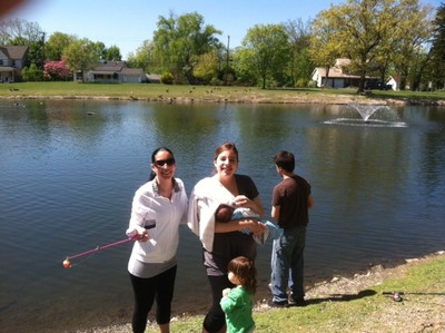 Photo by Jim Lennon. Wanda Morales (holding a fishing pole) and Talua Steinard (who is holding her baby Austin Steinard), while little Calli Morales watches her Mom fish. John Steinard (facing away) fishing in Pond.