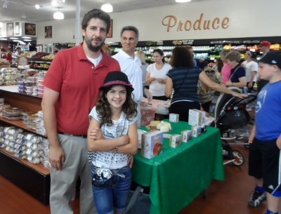 Frank DeCicco Jr., & and his daughter, stand next to sample table operated by 