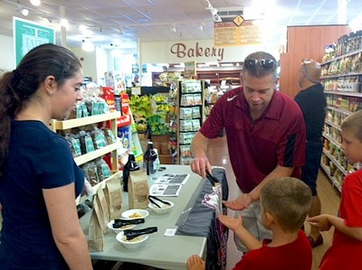 Deirdra Luedke of KoKo Pelli Cookie Company, Washingtonville  NY, watches as DeCicco customer Brian Zimmer and his sons, Brett age 5 and Griffin age 8 savor some samples during 