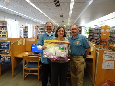 Photo by Jim Lennon. LtoR Peter Brandt, Librarian Charlotte Dunaief and Don Forte with the new donated LCD magnifier.