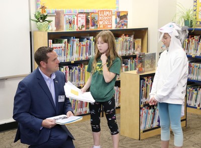 Orange County Executive Steven M. Neuhaus with at Willow Avenue Elementary School fourth-grade students Lorelai Fendt (left) and Brylee Moulton (right) at Mastodon Day.