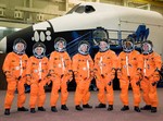 Full crew stands in front of the shuttle Atlantis