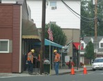 Power crew inspects a village light pole Tuesday