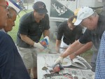 Other Lions Club members wrap the cooked lobsters in newspapers.