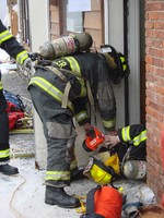 A fallen fire fighter is rescued from the smoke-filled building.