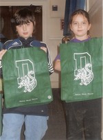 Fourth-graders from COHES display the green re-usable bags.