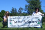 Cornwall Garden Club members (left to right) Andrea Hamburger and Angela Calabro, co-chairs of the club's 80th anniversary committee, place a sign inviting the community to the June 13 Tea on the Green. 