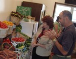 Co-op Marketplace manager William Hayes shows Assemblywoman Calhoun some of the produce in the store.