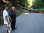 Officer Lug speaks with Ben Hinderman, who saw the tree fall.