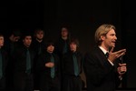 Eric Whitacre with members of the CCHS concert choir behind him.