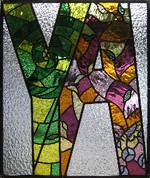 The stain glass reads YA, for Young Adult, a section of books in the library.