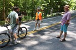 Trustee Barbara Gosda gets the emails of two bikers before the enter the closed section of Route 218 as former mayor Joe Gross looks on.