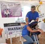 Timothy Vanderberg, owner of Caring Hands Massage, gives a massage to a volunteer at the work site.