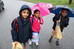 Keshav, Chitra and Prahlad Raval waited in the rain for the school bus.