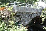 Cracks are visible on the side of the old stone bridge.