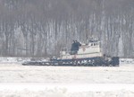 A tugboat chugs through the ice