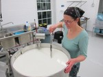 Talitha Thurau stirs a vat of goat's milk being processed.