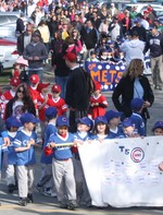 T-ball players from the Cubs team lead the march from town hall to the playing fields.