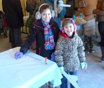Photo by Jim Lennon. Jacqueline (left - age 9) and her sister Victoria (right - age 5) await their turn to do crafts at the Groundhog Day Celebration