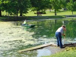 Photo by Jim Lennon. Alice Becker and Rich Watts clean algae from the pond.